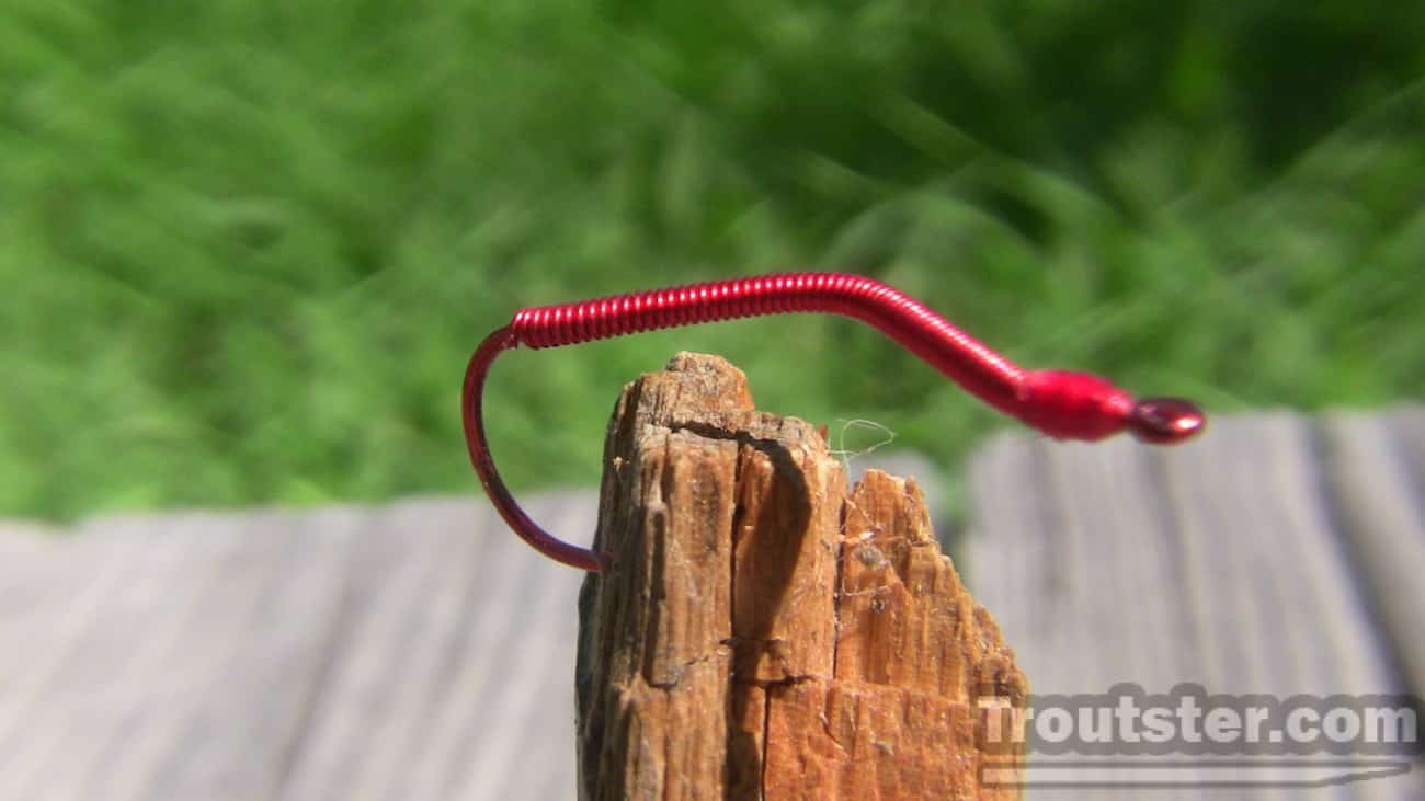 Red san juan style worm tied on a tru-turn hook. It consists of red wire and head cement. 