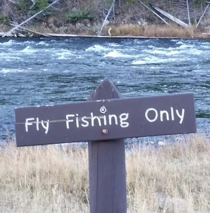 Fly fishing only sign on the Madison river in Yellowstone.